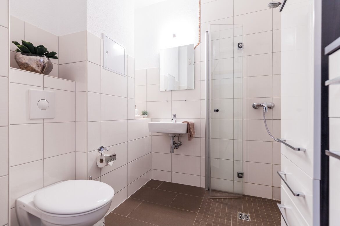 Bad mit Toilette, Waschbecken und ebenerdiger Dusche