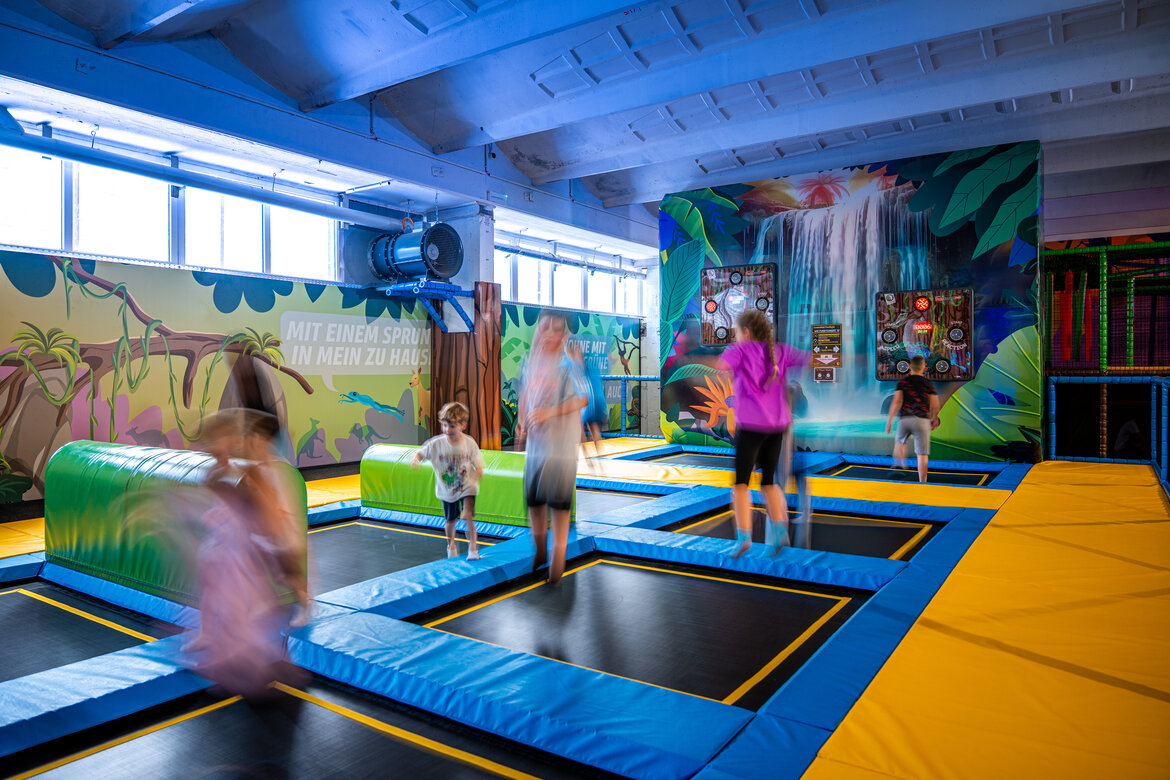 Springende Kinder auf Trampolinen im Erlebnishaus