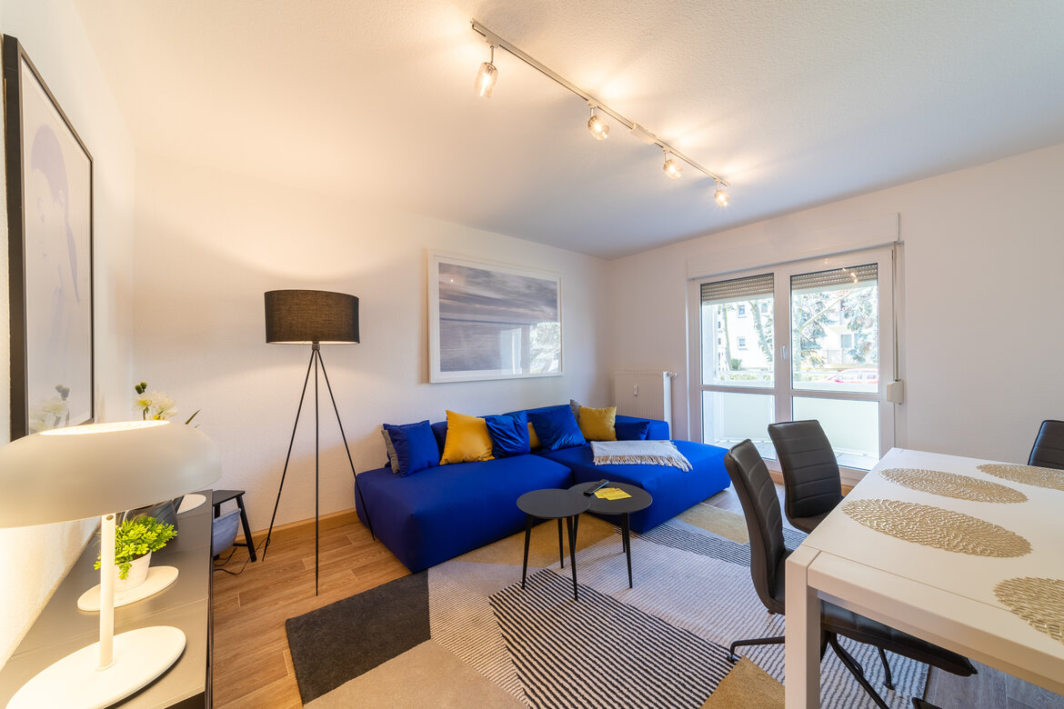 Sofaecke mit Stehlampe und Essbereich im Vordergrund