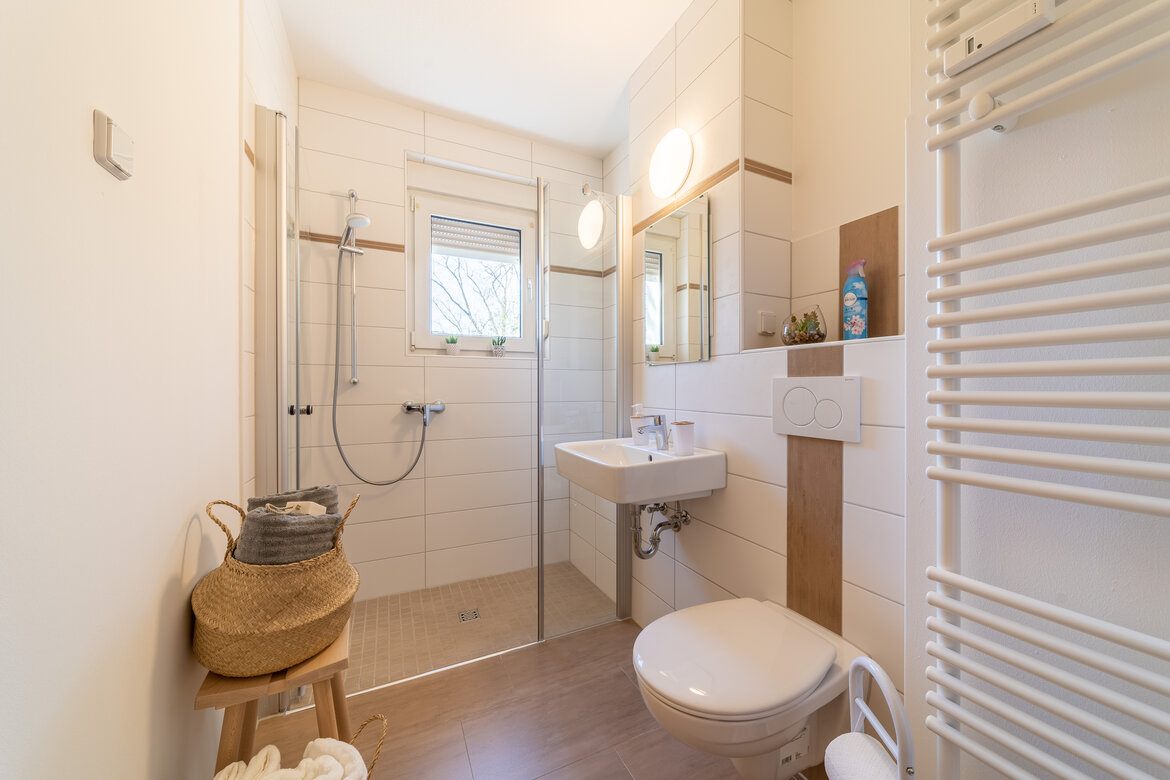 Bad mit Toilette, Waschbecken und ebenerdiger Dusche