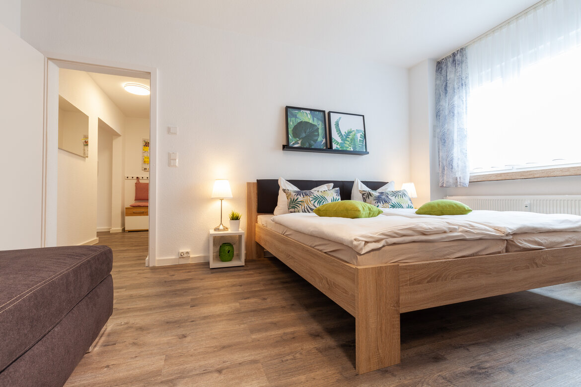 Schlafzimmer mit Doppelbett, Nachtschrank und Schlafsofa