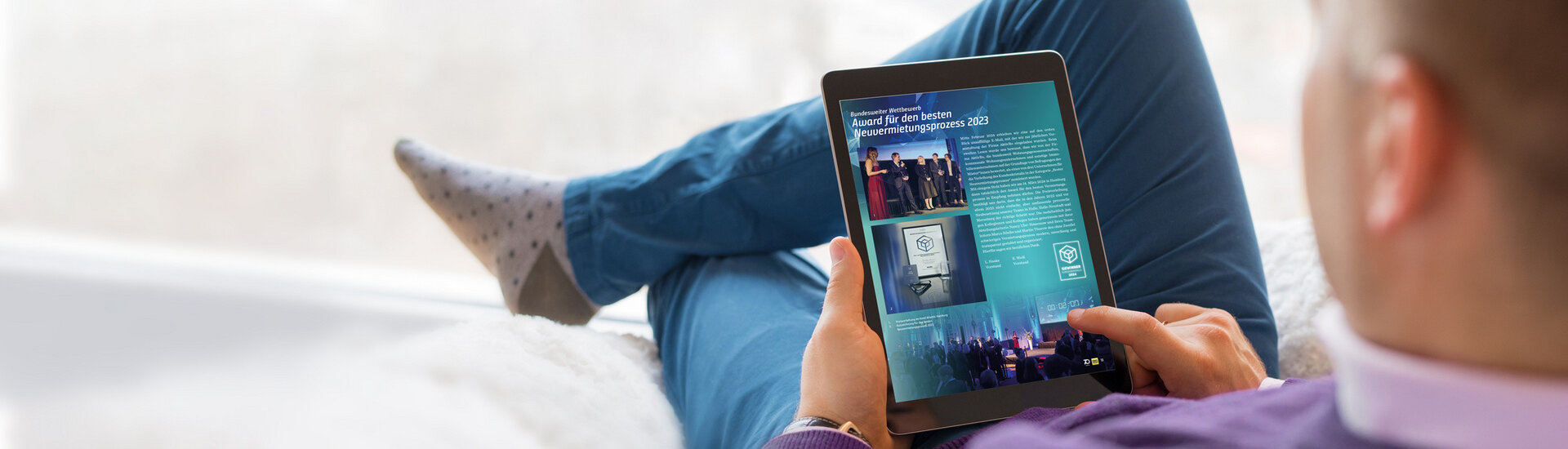 Person mit Tablet in der Hand auf dem unser Mitgliedermagazin zu sehen ist